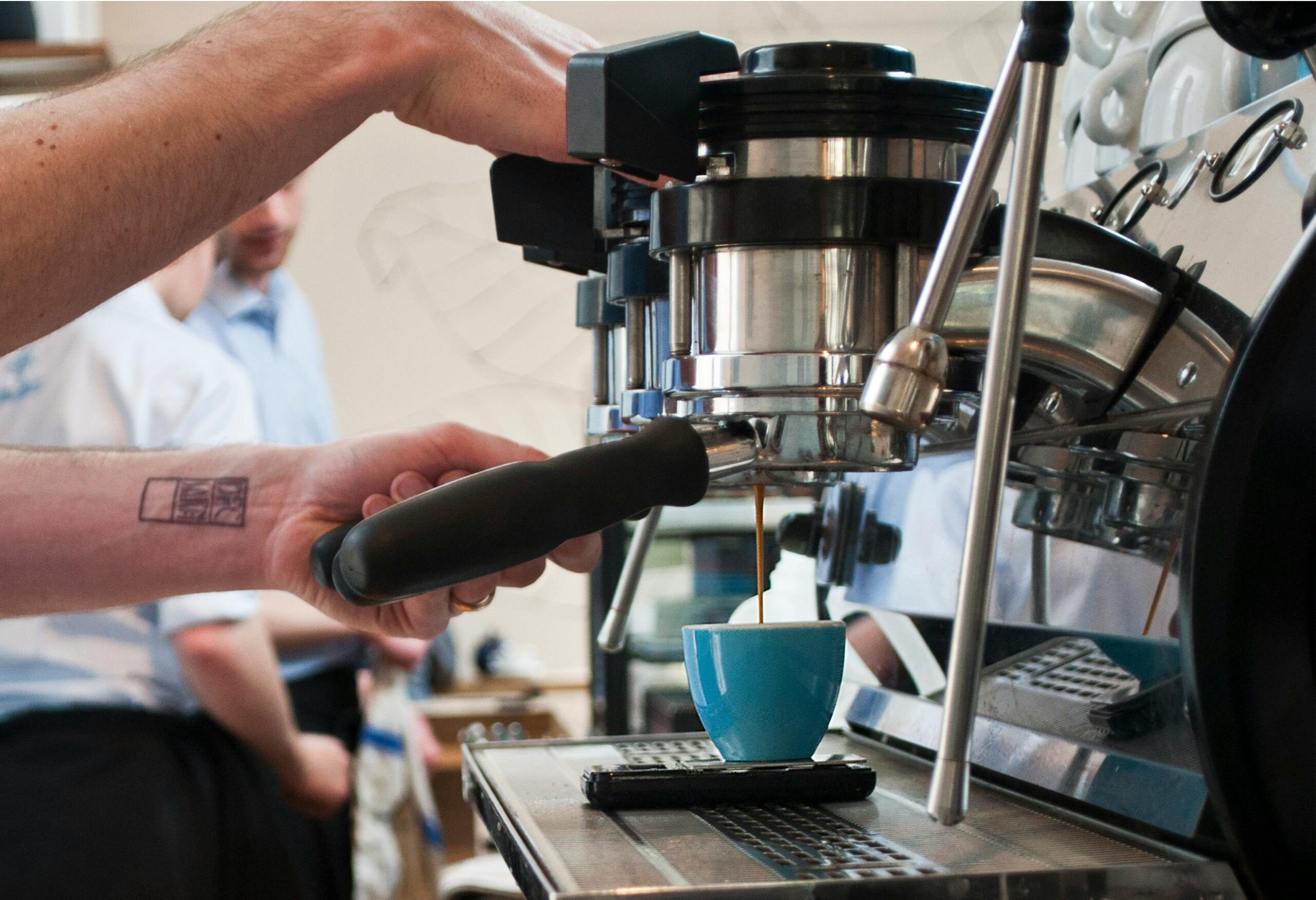 Commercial espresso machine preparing coffee in a busy café during morning service hours