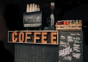 Comparison between a commercial espresso machine and a home espresso machine showing professional cafe equipment versus household coffee equipment.