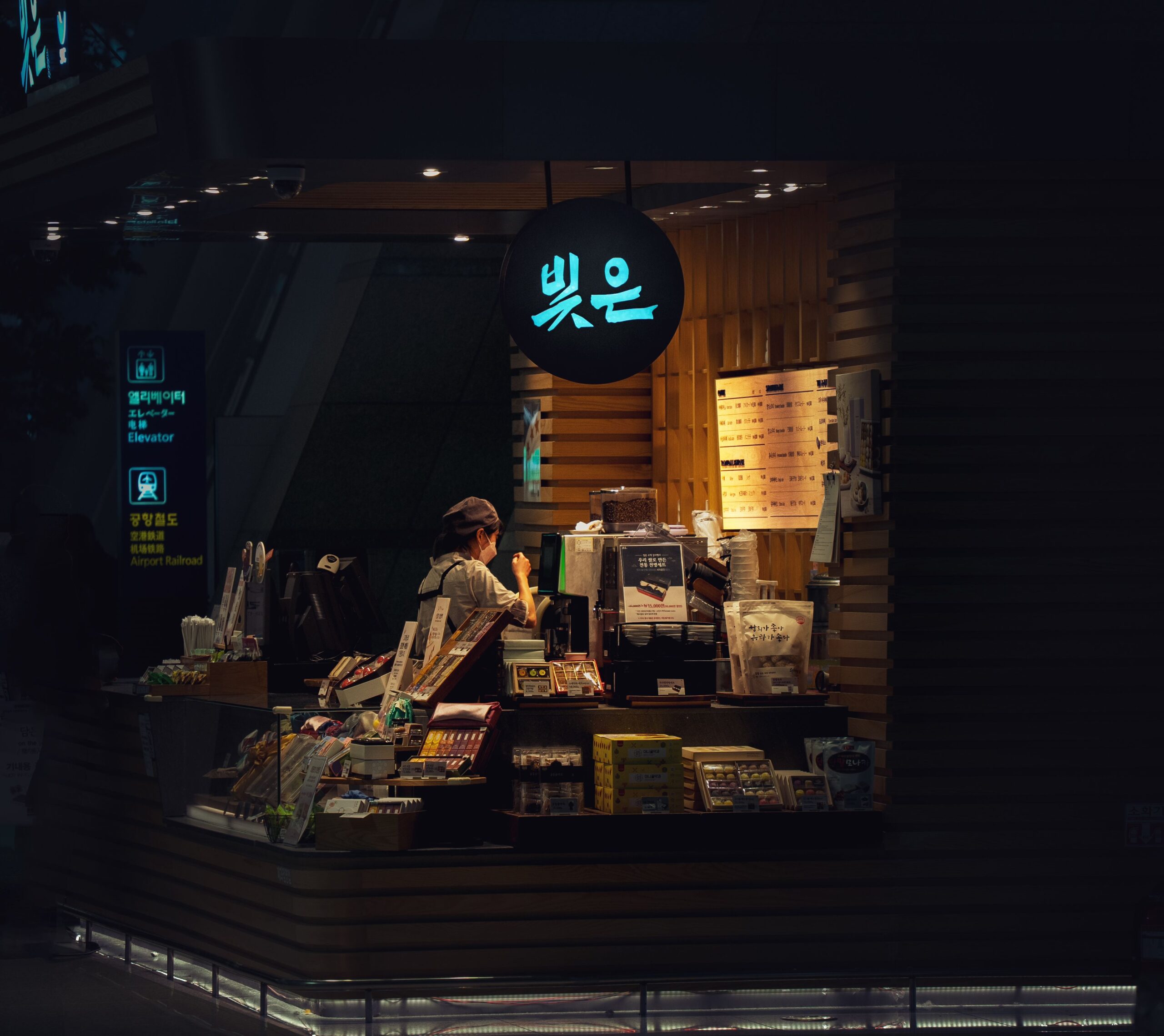 barista calibrating a commercial coffee syrup dispenser in a modern cafe
