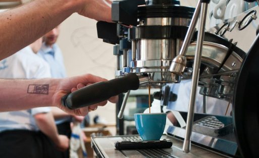Commercial espresso machine preparing coffee in a busy café during morning service hours